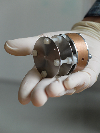 Single cavity ECR source with two aperture electrodes Photo of a single cavity ECR source module with two aperture electrodes, presented on a gloved hand palm